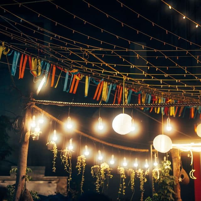 String lights and bunting over a garden party at night